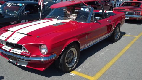 2007 Ford Mustang - Classic red 1968 Ford Mustang convertible with racing stripes and a surfboard on the roof.