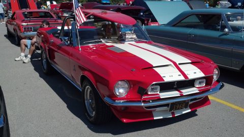 2007 Ford Mustang - A red 1968 Shelby Mustang convertible is displayed at a car show with other vehicles.