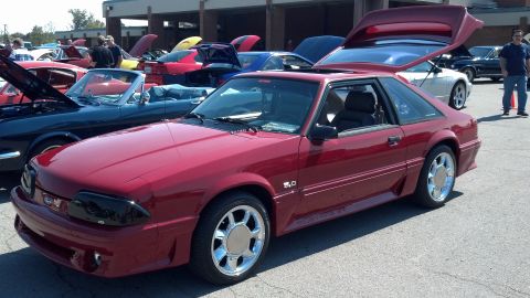 2007 Ford Mustang - Red coupe with trunk open, "5.0" and "MUSTANG GT" badges visible at a car show.