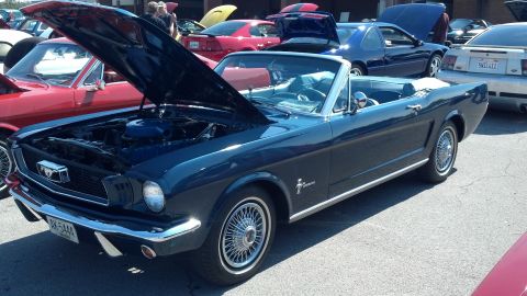 2007 Ford Mustang - A classic dark blue convertible Mustang is displayed with its hood open at an outdoor car show.