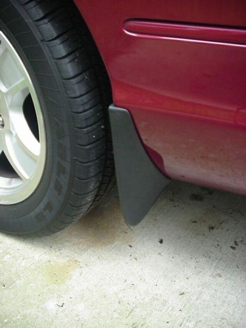 2002 Ford Crown Victoria - Close-up of a car's rear wheel well area, showing the tire and mud flap.
