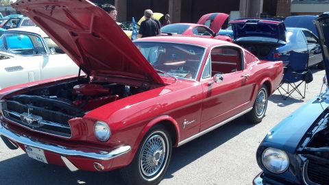 2007 Ford Mustang - A red 1965 Ford Mustang is displayed at a car show with its hood open.