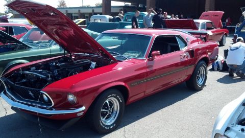 2007 Ford Mustang - A red 1969 Ford Mustang Mach 1 is displayed with its hood open at a car show.