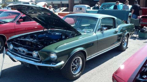 2007 Ford Mustang - A green 1967 Ford Mustang fastback is displayed with its hood open at a car show.