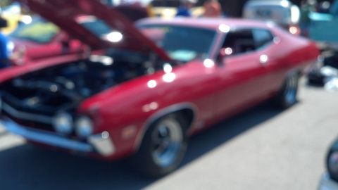 2007 Ford Mustang - A red classic car is displayed with its hood open, revealing the engine bay.