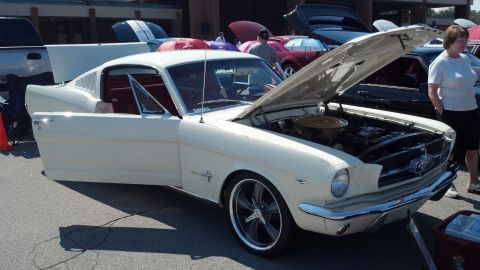 2007 Ford Mustang - A classic white 1965 Ford Mustang is displayed with its hood and doors open at an outdoor car show.