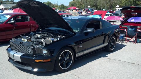2007 Ford Mustang - Black 2007 Ford Mustang Shelby GT on display at a car show with its hood open.
