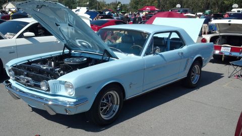 2007 Ford Mustang - A classic light blue Ford Mustang coupe is displayed with its hood and trunk open at a car show.