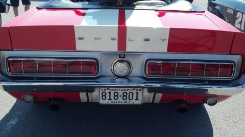 2007 Ford Mustang - Rear view of a red and white Shelby Mustang, racing stripes and Shelby badging. The license plate reads 818-801.