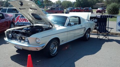 2007 Ford Mustang - A white 1967 Ford Mustang is displayed with its hood open at a car show, with other vehicles and a banner visible.