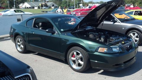 2007 Ford Mustang - A dark green Ford Mustang is displayed with its hood open at an outdoor car show.
