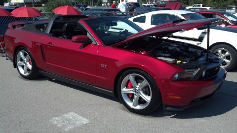 2007 Ford Mustang - A red convertible Ford Mustang GT is parked with its hood open at an outdoor car show.