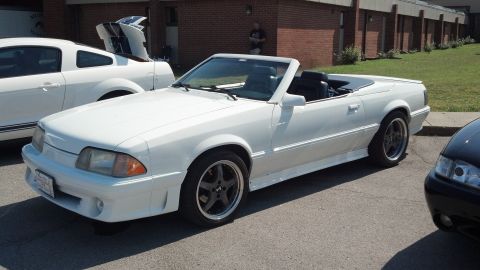 2007 Ford Mustang - A white convertible is parked in front of a brick building, with another white Mustang behind it.