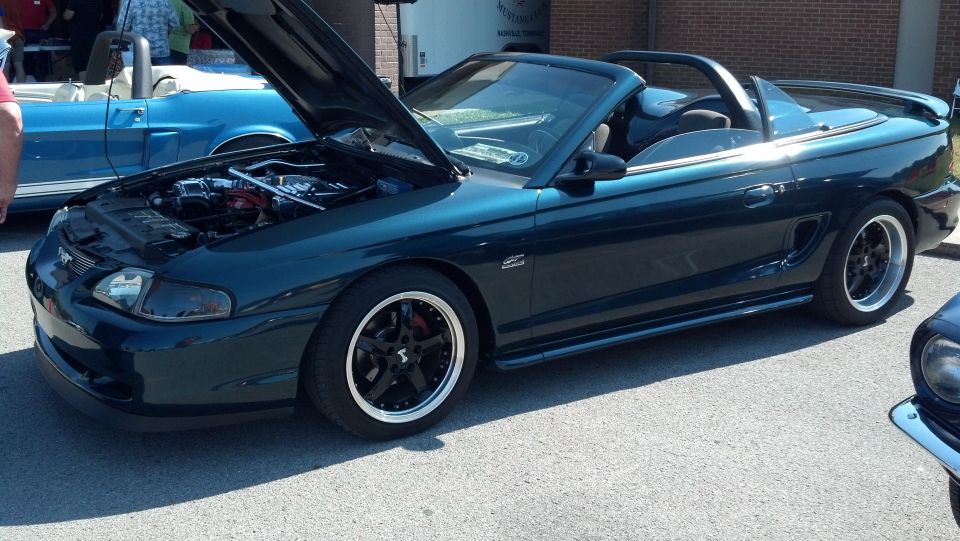 Dark teal 1994 Ford Mustang convertible with hood open, black wheels