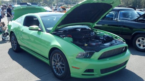 2007 Ford Mustang - A green Ford Mustang is displayed with its hood open at a car show.