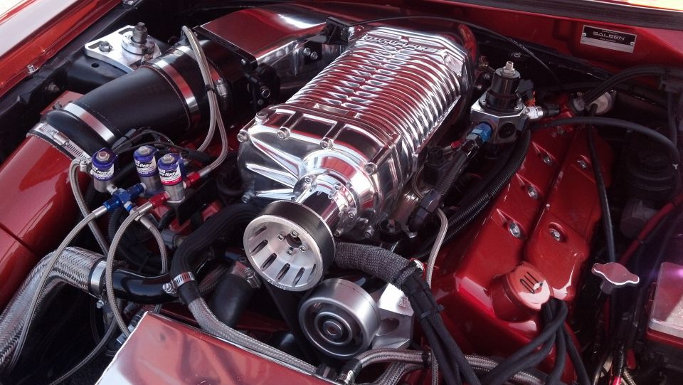 Red engine bay with polished supercharger, intake, and fuel rails