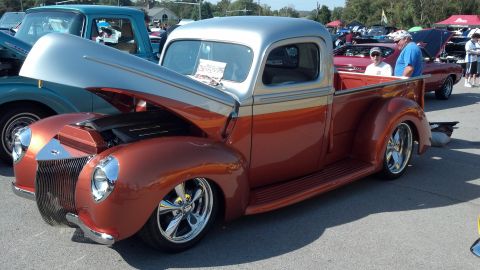 2007 Ford Mustang - A custom hot rod pickup truck with a two-tone paint job and chrome wheels is displayed at an outdoor car show.