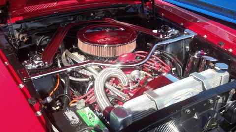 2007 Ford Mustang - Close-up of a classic car's engine bay with custom chrome components and red accents.