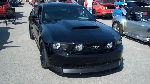 2007 Ford Mustang - A black Ford Mustang is parked at a car show, with other vehicles visible in the background.