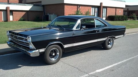 2007 Ford Mustang - This black 1967 Ford Fairlane is parked curbside in front of a brick building.