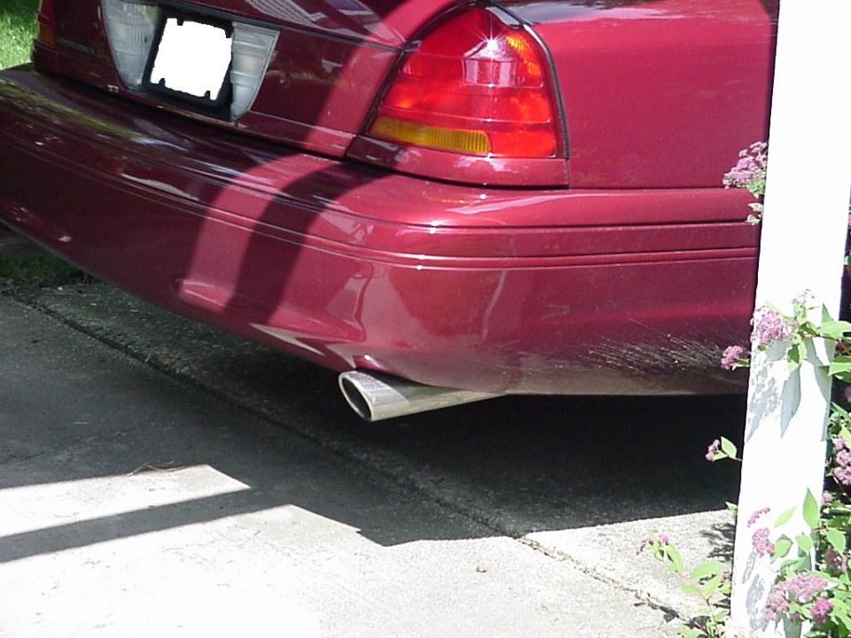 Rear of maroon Crown Victoria with chrome exhaust tip under the bumper