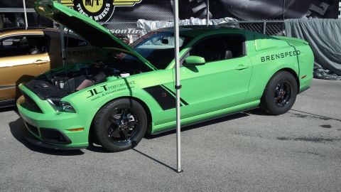 2007 Ford Mustang - Modified Ford Mustang on display, hood open showing engine bay. Another vehicle is partially visible behind it.