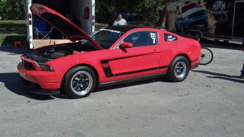 2007 Ford Mustang - Red 2007 Ford Mustang Boss 302 modified for racing, hood open, parked outdoors.