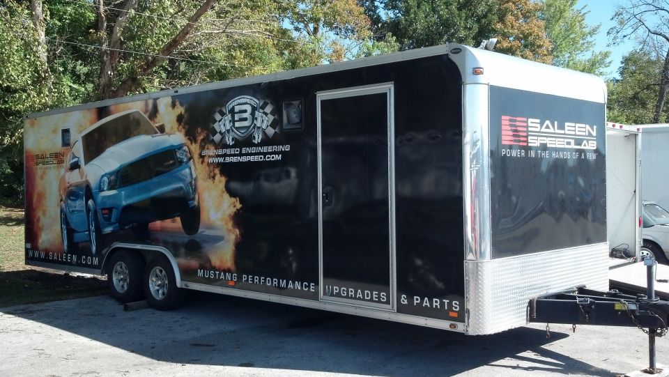 enclosed trailer with graphics of a blue car on fire, Saleen Speedlab branding, and text about Mustang performance upgrades