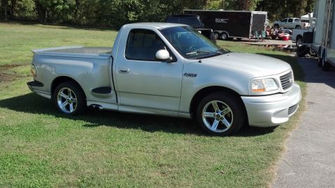 2007 Ford Mustang - A silver pickup truck is parked on a grassy area next to a paved surface.