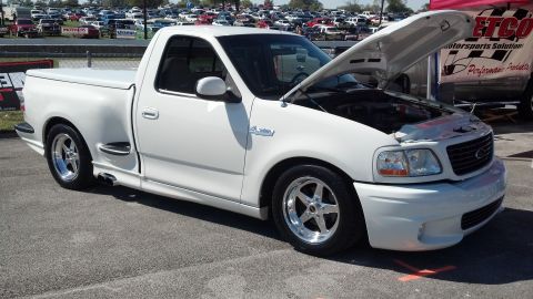2007 Ford Mustang - A white Ford F-150 Lightning pickup truck is shown with its hood open, parked outdoors.