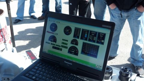 2007 Ford Mustang - A laptop displays engine diagnostic data, including RPM and AFMI readings, at an outdoor event.