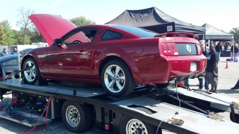 2007 Ford Mustang - Red 2007 Ford Mustang coupe on a car trailer, hood open, at an outdoor event.
