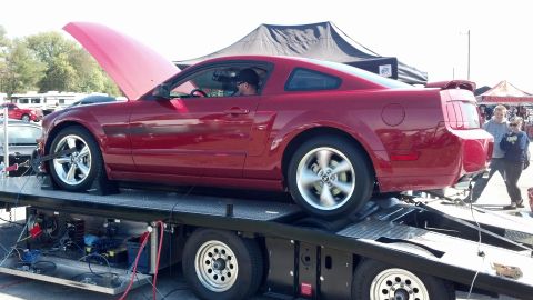 2007 Ford Mustang - A red Ford Mustang is on a dynamometer with its hood open, viewed from the side.