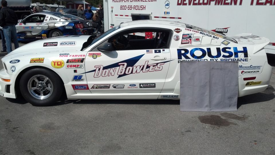 White 2007 Ford Mustang race car with ROUSH livery, side view