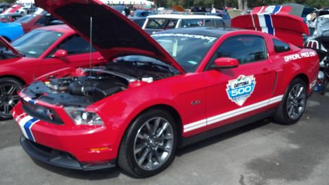 2007 Ford Mustang - A red Ford Mustang with racing decals and an open hood is parked outdoors with other vehicles.