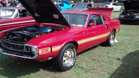 2007 Ford Mustang - A red 1969 Ford Mustang GT500 is displayed with its hood open at an outdoor car show.