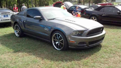 2007 Ford Mustang - Gray Ford Mustang parked on grass at an outdoor car show.