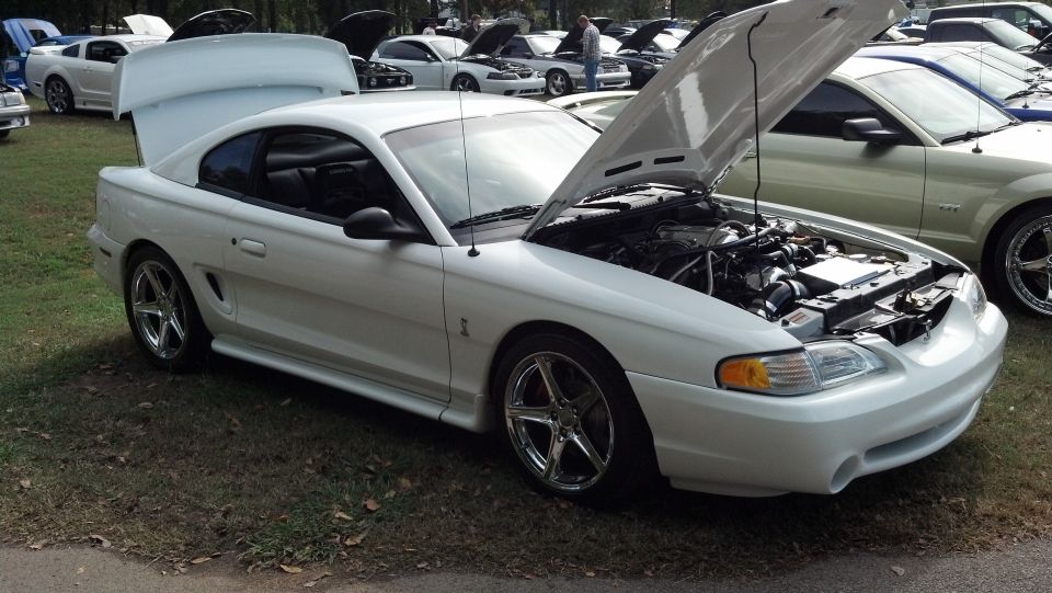 White Ford Mustang, 1994 model year, with hood open, parked on grass