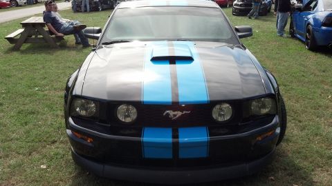 2007 Ford Mustang - Front view of a black 2007 Ford Mustang with blue racing stripes at an outdoor car show.