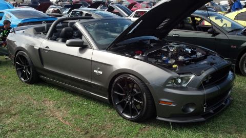 2007 Ford Mustang - A gray Ford Mustang convertible is parked on grass with its hood open, displaying the engine bay.