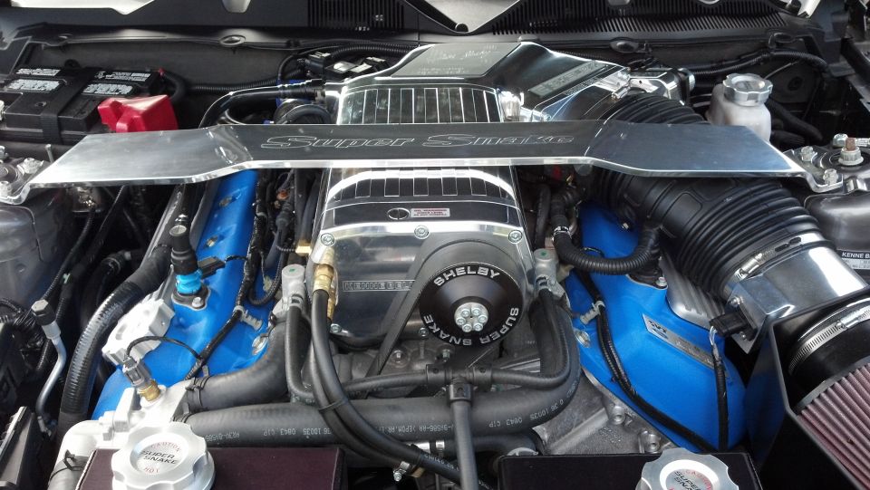 Engine bay with a supercharger and blue valve covers, labeled "Shelby Super Snake"