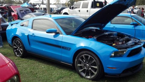 2007 Ford Mustang - A blue Ford Mustang GTCS is parked on grass with its hood open, showing the engine bay.