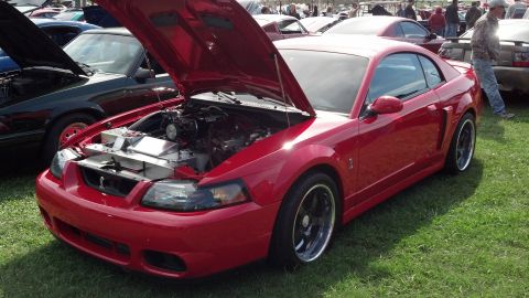 2007 Ford Mustang - Red 2007 Ford Mustang coupe at a car show, hood open to display the engine bay.