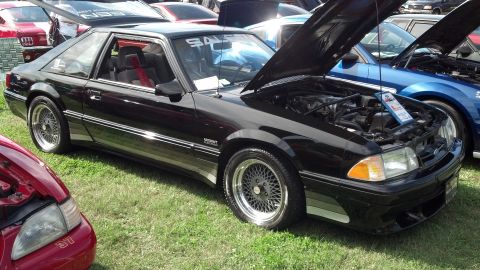 2007 Ford Mustang - A black Saleen Mustang is displayed with its hood open, its engine bay and custom body modifications.