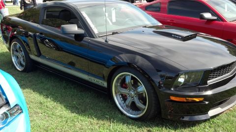 2007 Ford Mustang - Black 2007 Ford Mustang GT/CS parked on grass next to a red car.