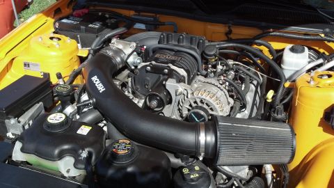 2007 Ford Mustang - Close-up view of a modified engine bay a prominent Roush supercharger and air intake system.