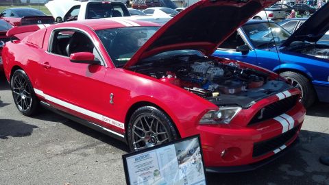 2007 Ford Mustang - A red 2007 Ford Mustang GT 500 is displayed with its hood open at an outdoor event.