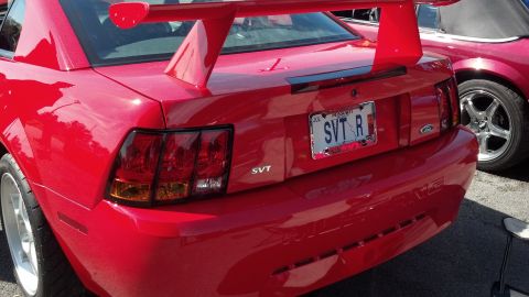 2007 Ford Mustang - A red 2007 Ford Mustang SVT is seen from the rear, a prominent spoiler and custom license plate.