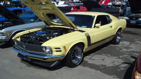 2007 Ford Mustang - A yellow 1970 Ford Mustang Boss 302 is displayed with its hood open, revealing the engine bay.
