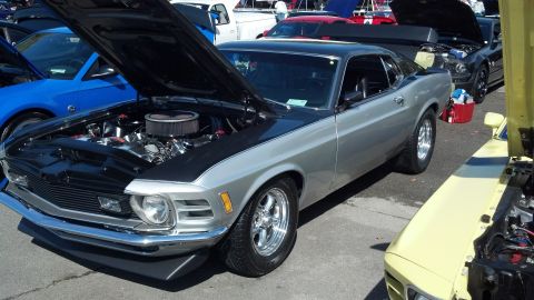2007 Ford Mustang - A silver 1970 Ford Mustang is displayed with its hood open, parked alongside other vehicles.